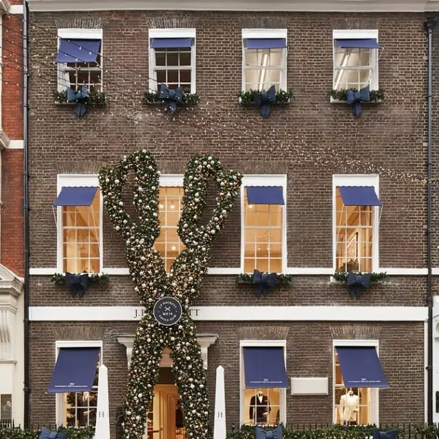 Hackett flagship townhouse on Savile Row with navy awnings and a giant Christmas-bauble scissors sculpture
