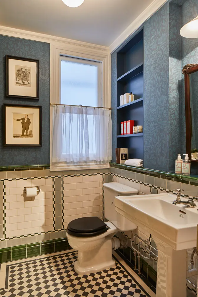 Heritage-style WC at Hackett Savile Row with pedestal basin, toilet, metro tiles and exposed chrome pipework